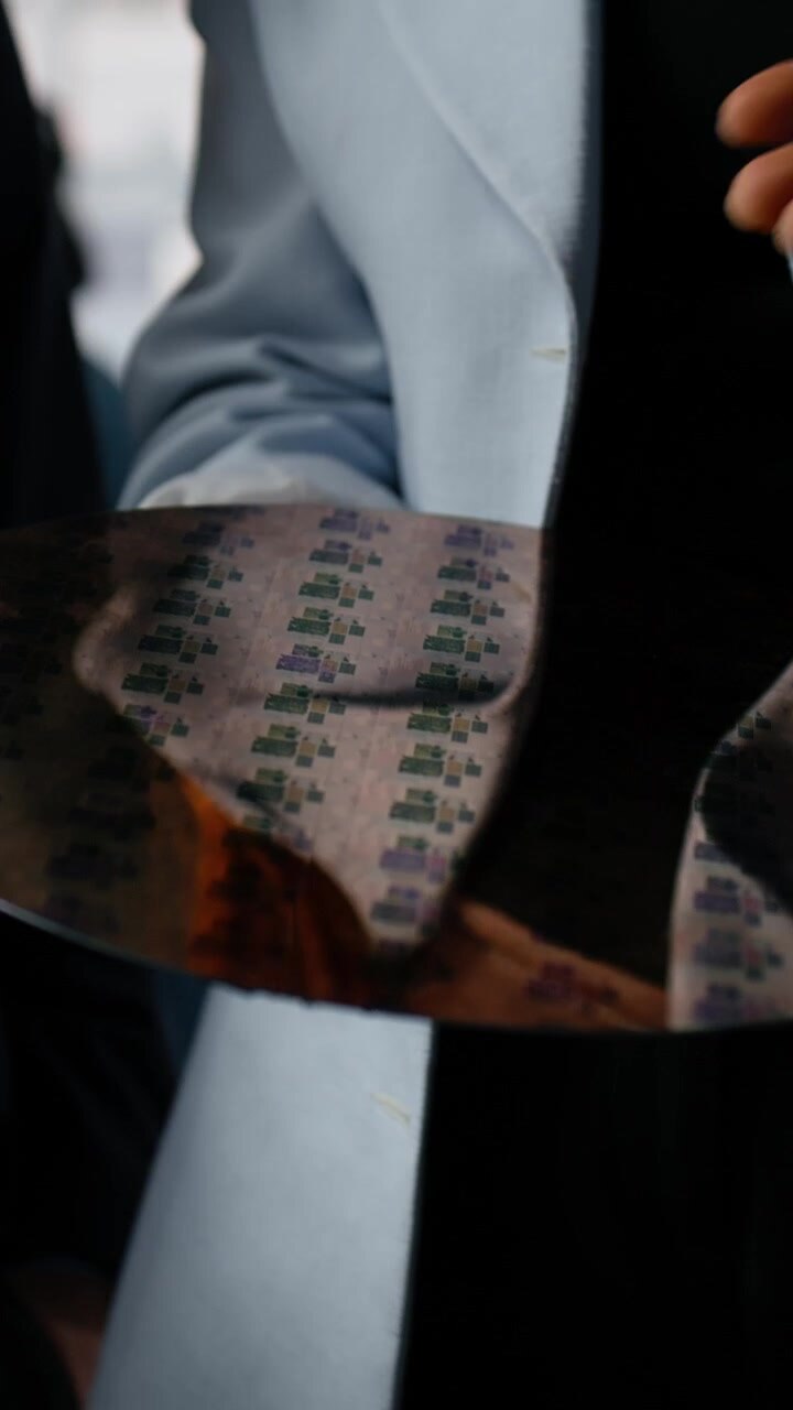 Vertical video Close up of diverse researchers examining silicon wafer in factory office