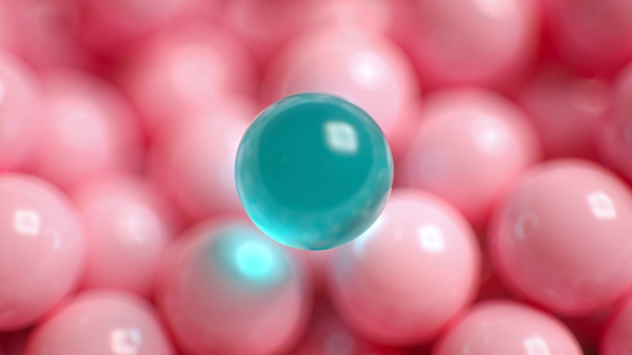 Sfera trasparente color verde acqua che si alza e si muove verso l'alto sopra un fitto letto di perline rosa lucide, stimolata da un punto luminoso.