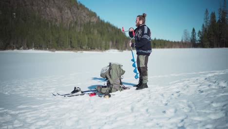 Backpacker-On-A-Frozen-Landscape-With-Hand-Auger