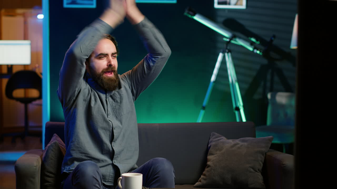 hombre emocionado en casa disfrutando de la competencia de fútbol, aplaudiendo