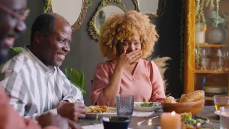 african american woman talking to family at holiday dinner