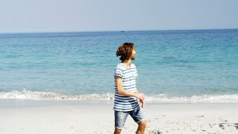 Friends-playing-with-american-football-at-beach