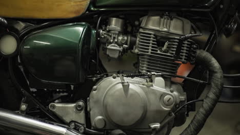 close up of engine, seat and fuel tank of classic retro green motorbike