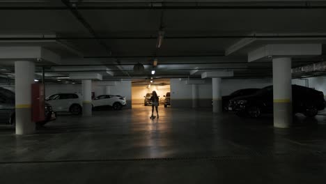 un estacionamiento subterráneo. una chica joven patinando.