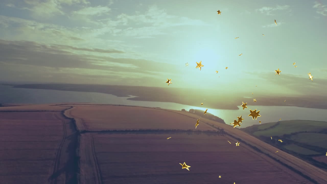 Golden star confetti drifting over patchwork fields and coastal inlet in warm sunlight flat design