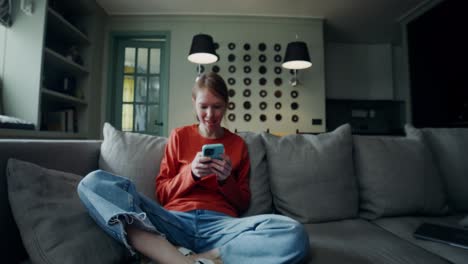 woman using phone on couch in modern living room