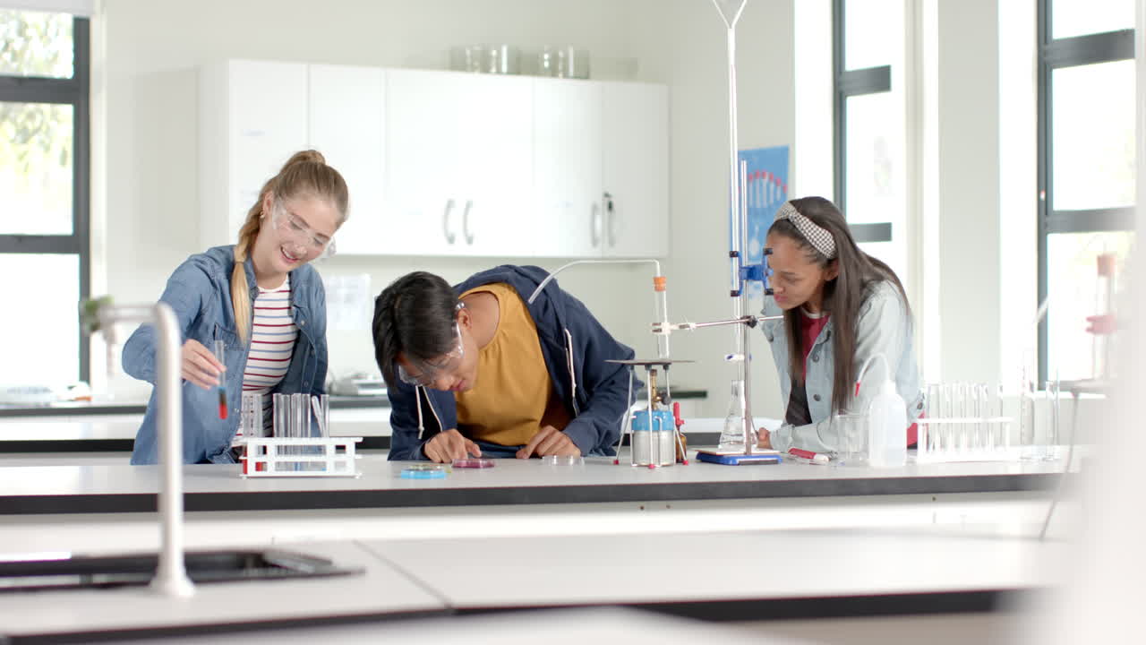 In high school laboratory, teenagers conducting science experiment with test tubes and beakers
