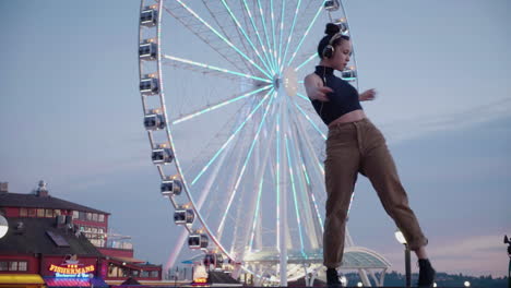 young, female, contemporary dancer near an urban ferris wheel