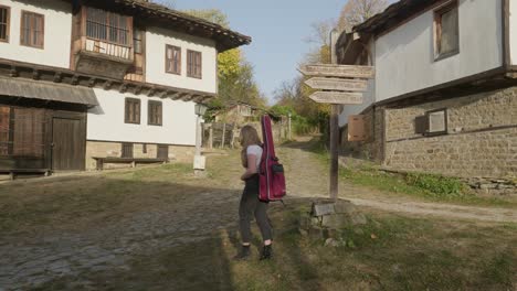 female musician follows signpost direction rural charm rustic village