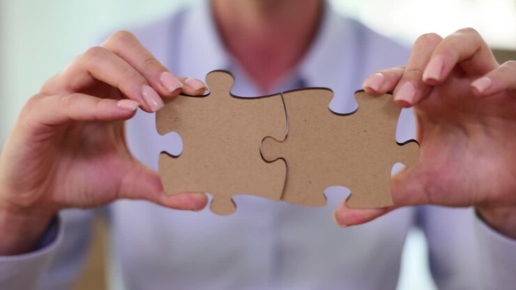 Mani che tengono due pezzi di puzzle collegati