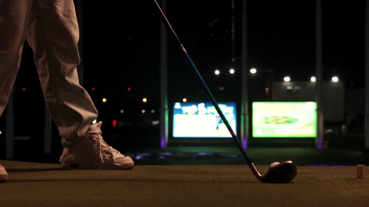 Golfista che pratica lo swing di notte a Bangkok