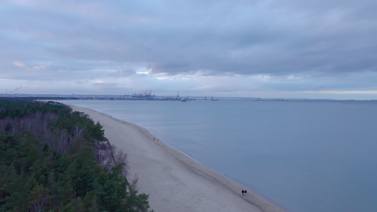 górki zachodnie en gdansk - varias personas caminan por la playa con vistas al puerto de gdansk