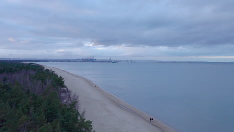 Górki-Zachodnie-En-Gdansk---Varias-Personas-Caminan-Por-La-Playa-Con-Vistas-Al-Puerto-De-Gdansk