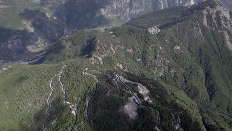 Drone-video-of-"front-descriptive-panning"-plane,-advancing-on-the-highest-of-the-sh21-the-Theth-mountain-pass-in-albania,-Gjecaj,-ending-with-the-views-of-the-horizon-of-the-mountains