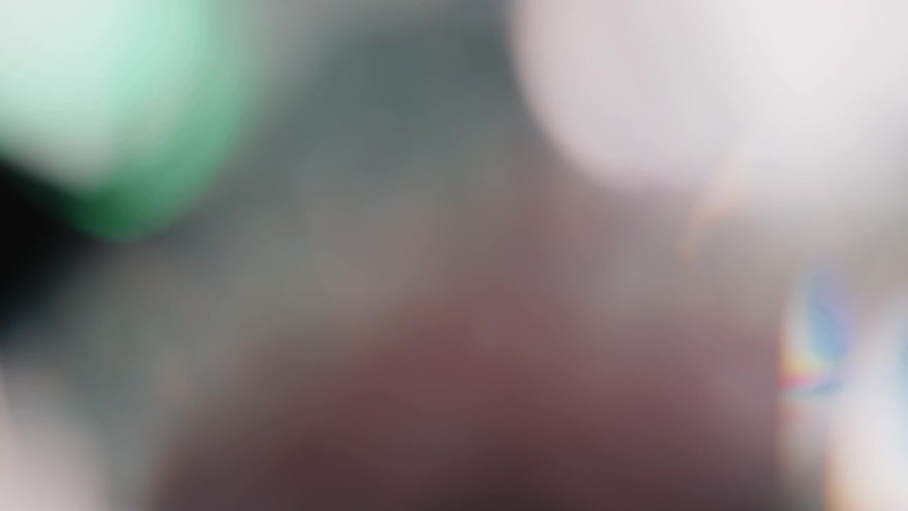 Filmato 4K di perdite di luce multicolore su sfondo nero, che stilizza le transizioni video con effetto bokeh