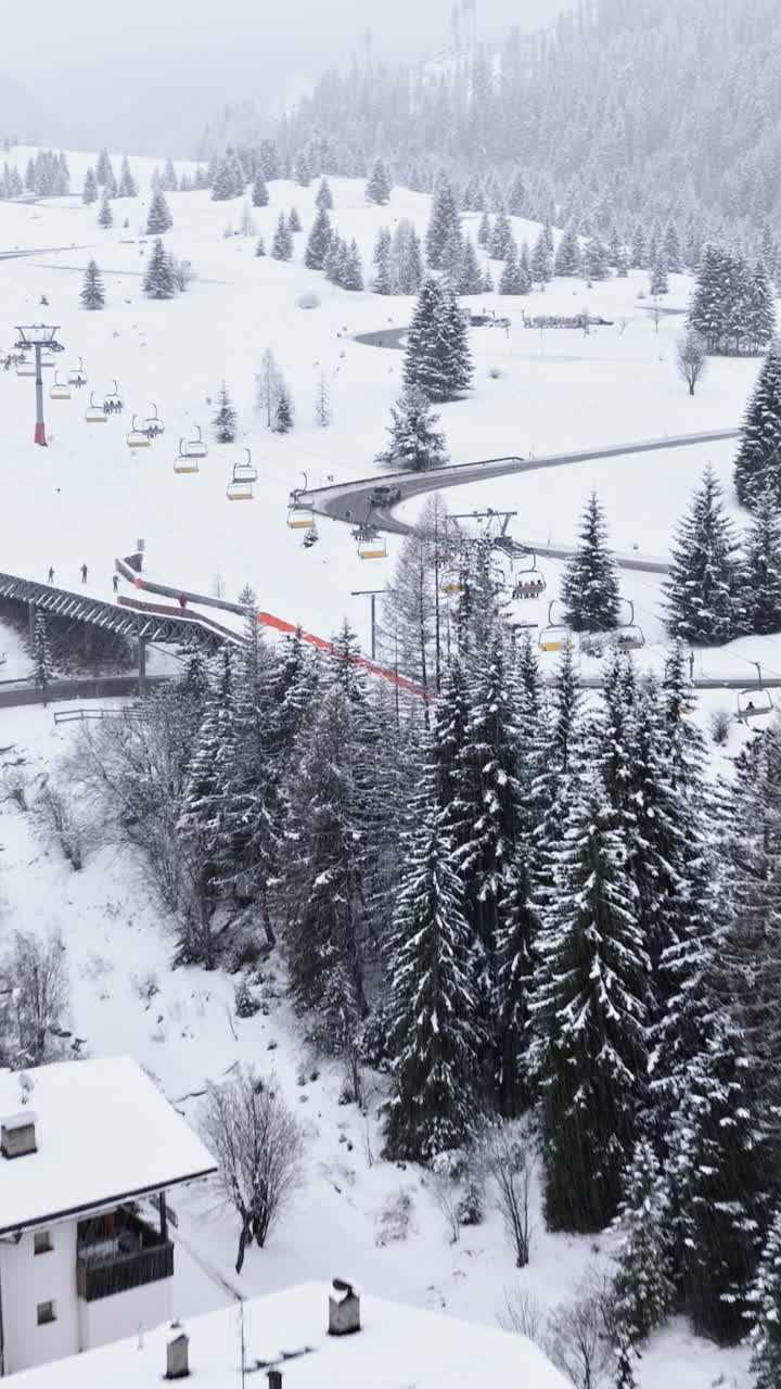 Aerial drone view of the Corvara village covered in snow, in South Tyrol, Dolomites, in northern Italy. Vertical