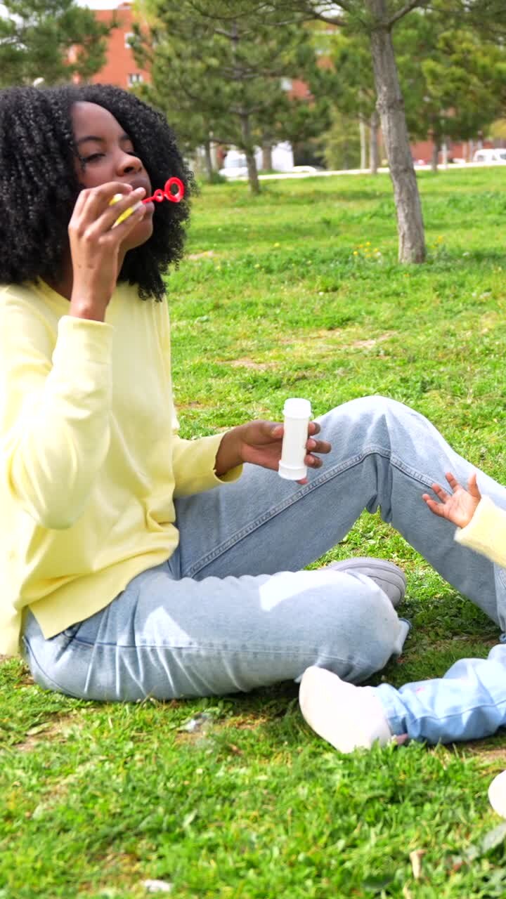 Madre e figlio giocano con le bolle di sapone nel parco