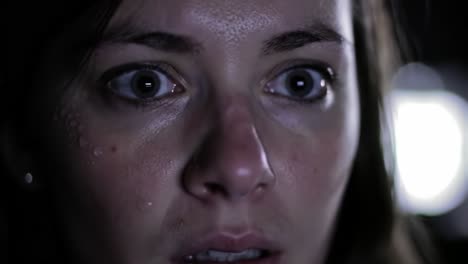 a woman's intense expression of fear and anxiety captured in close-up, highlighting the depth of emotion and suspense in a moment of distress