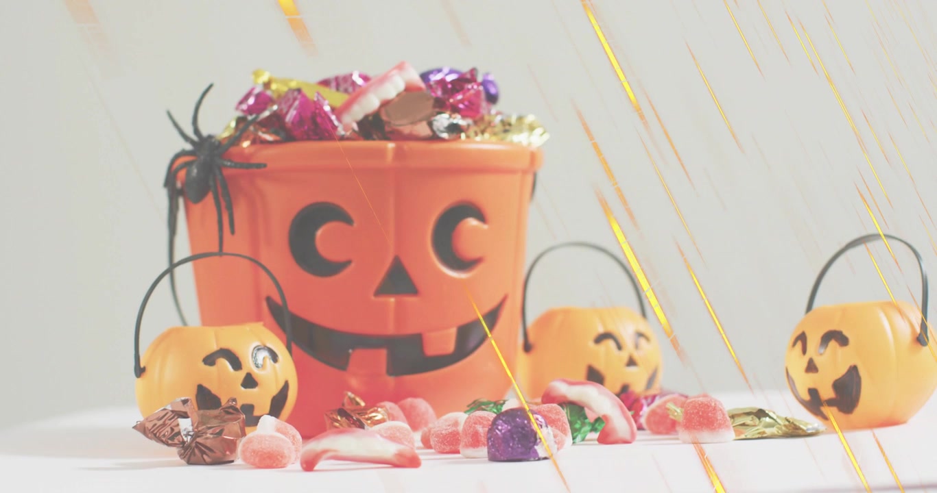 golden light streaks appearing and sweeping across jack o lantern bucket pails highlighting candies