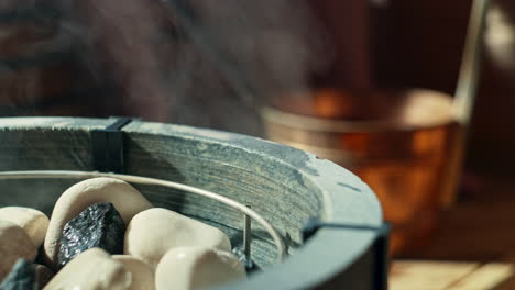 throwing water on hot sauna stones in sauna stove, using a scoop or ladle and getting the water from a water bucket called a kip or pail