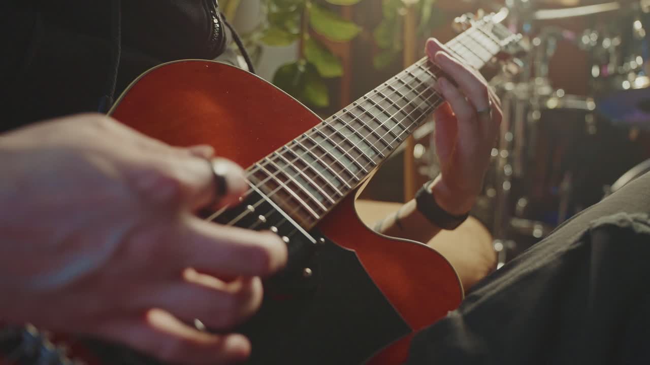Person Playing a Red Jazz Guitar