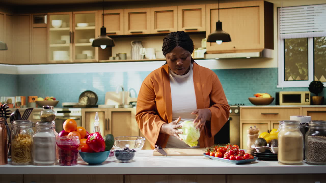 Content creator di cibo di colore che prepara foglie di lattuga iceberg in un video di cucina