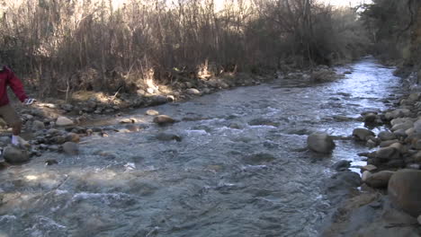 pan of people testing the water flowing in san antonio creek in ojai california