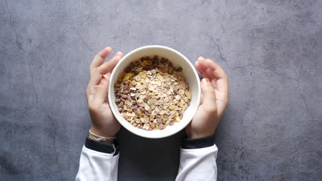 child holding a bowl of granola musli