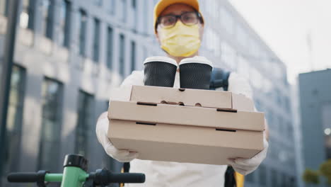 persona de entrega de comida con pizza y café