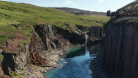 Luftaufnahme-Der-Studlagil-Schlucht-Mit-Basaltsäulen-Und-Gletscherwasserfluss-Zwischen-Zwei-Lavawänden.-Berühmte-Touristenlandschaft-Mit-Basaltfelsen-Und-Jokulsa-Fluss