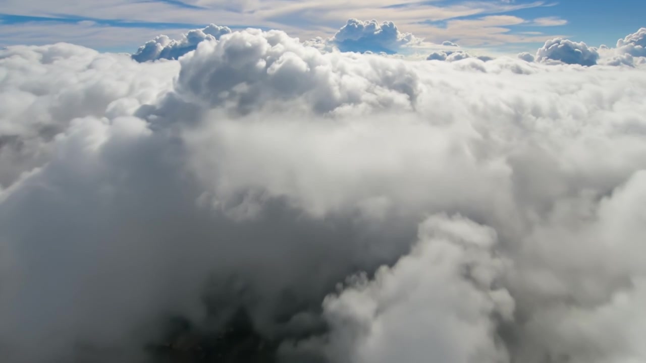 Breathtaking aerial view above a dense layer of fluffy white clouds under a clear blue sky