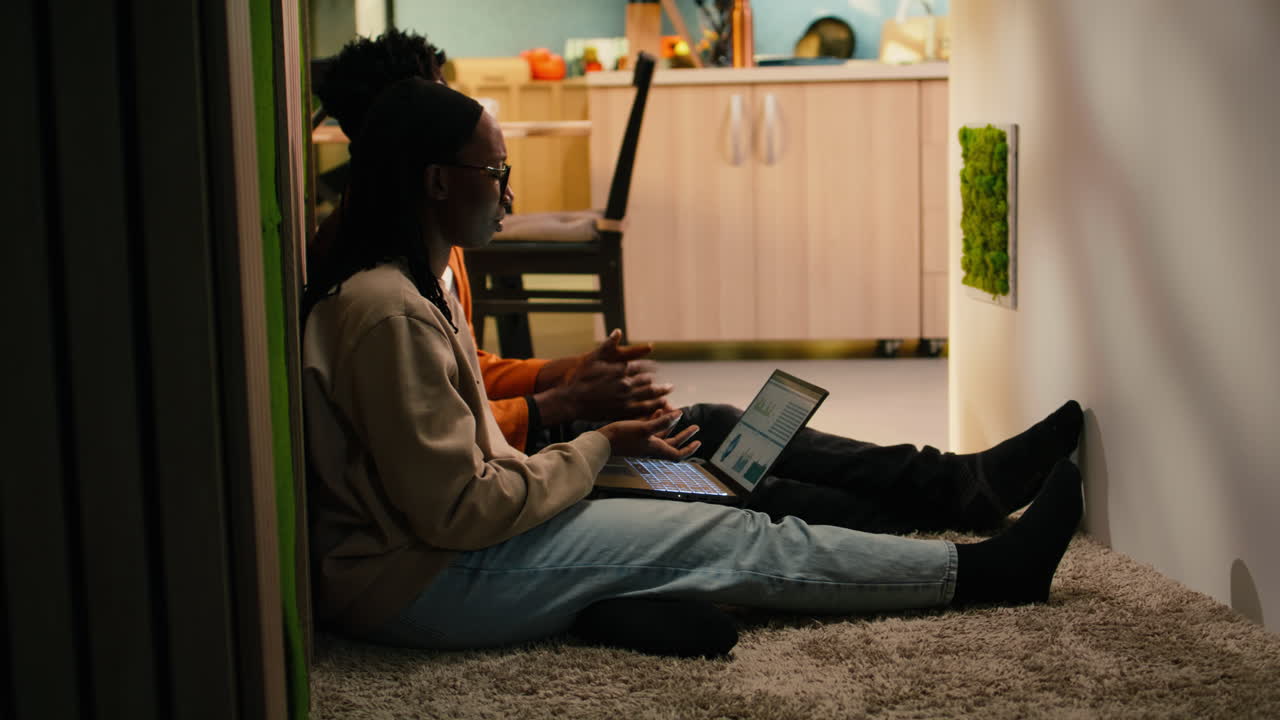 Black people reviewing data analytics on charts from their cozy home