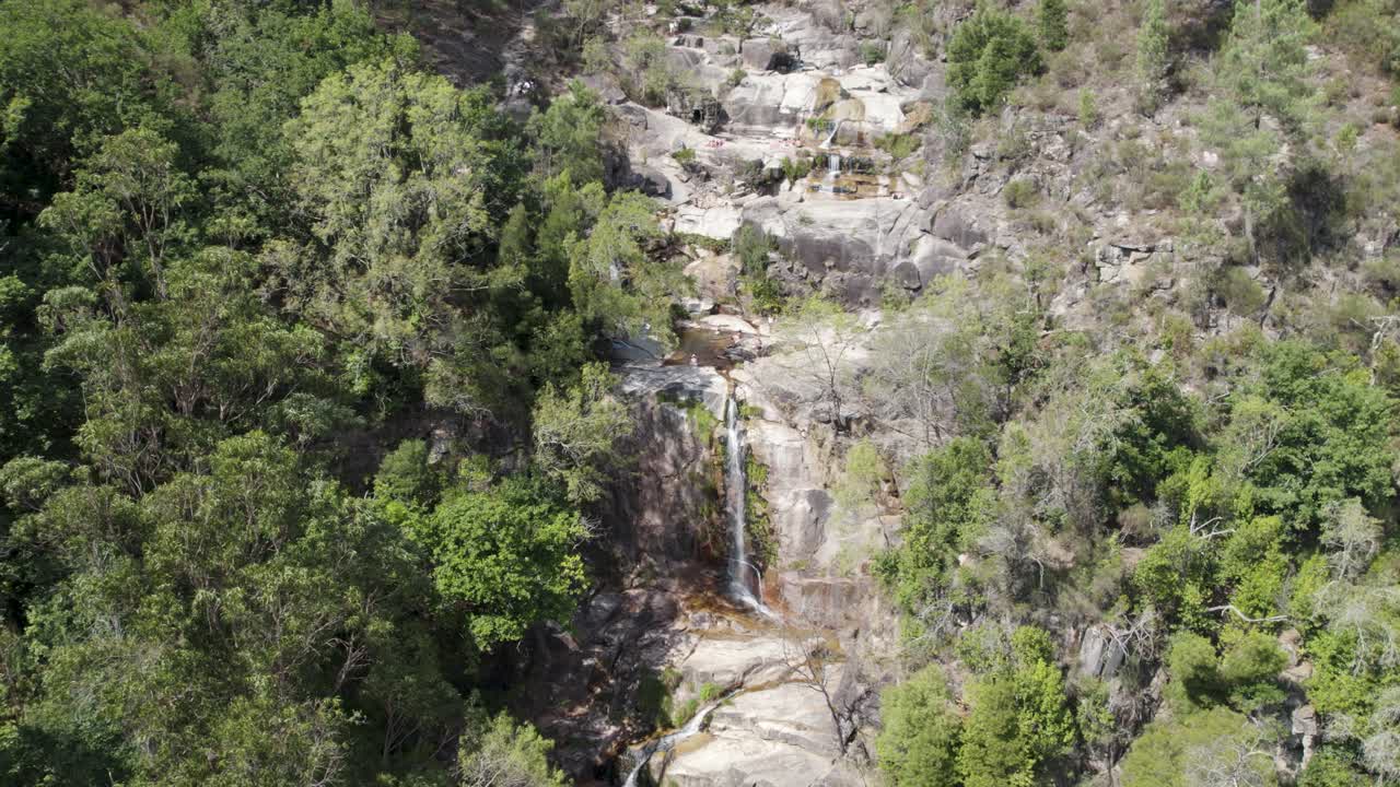 vista aérea sobre el parque nacional de gerês, cascada cascada, que fluye por la colina de roca, portugal