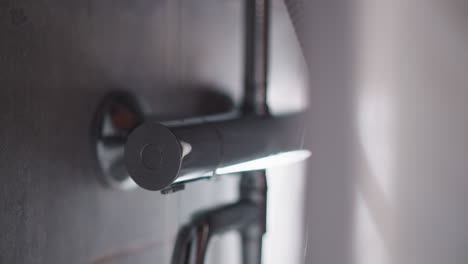 clean water sprays fall down in shower unit closeup. turning on hot water to wash body in home bathroom. modern chrome equipment of washroom