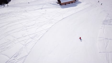 4k-aerial-footage,-drone-following-skiers-on-ski-slope-in-skiing-region