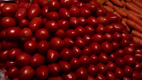 close up shot of little red locos, tomatoes and carrots exposed at central supply market in paraguay