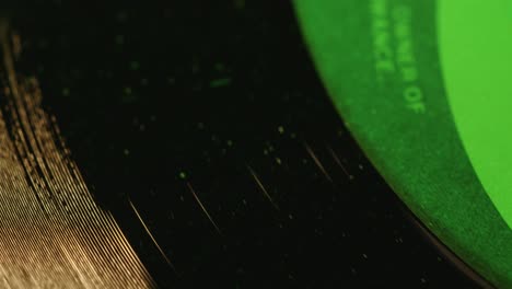 Grooves-and-surface-of-1-record-spinning-in-green-lighting