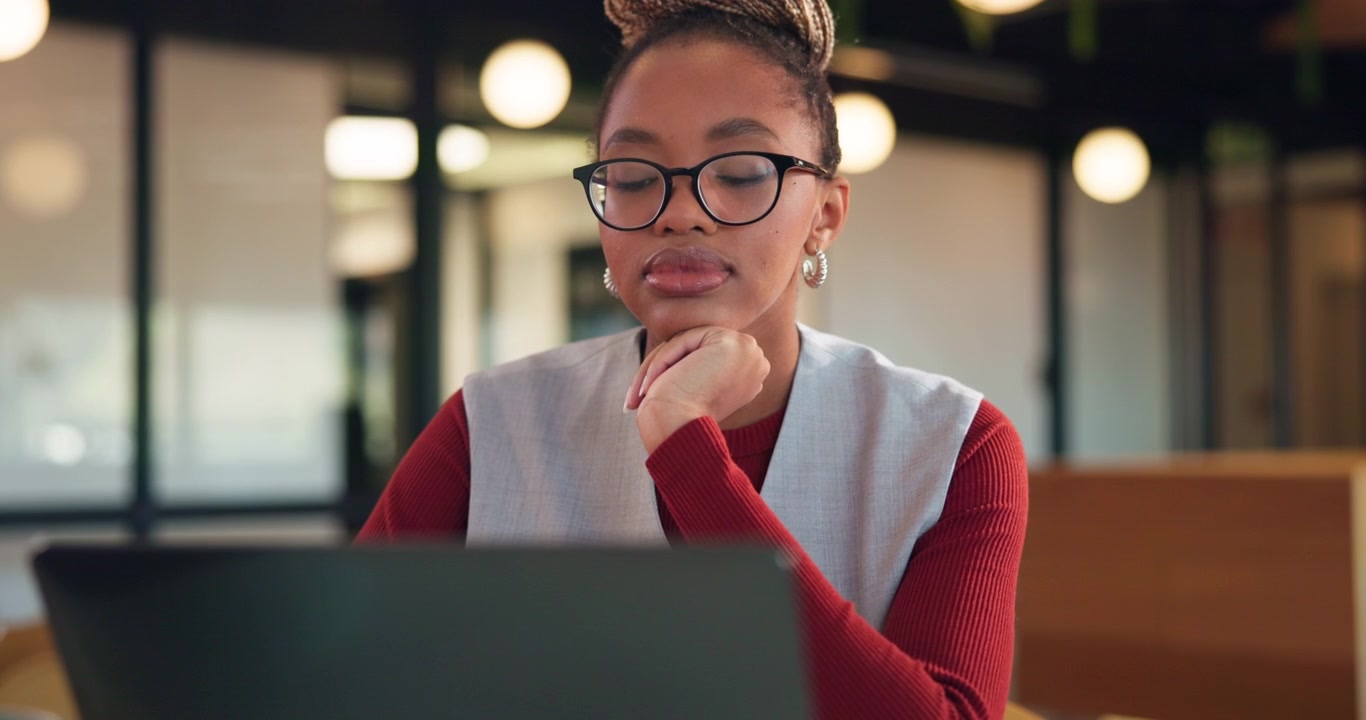 Focused Young Woman Working on Laptop in Modern Office