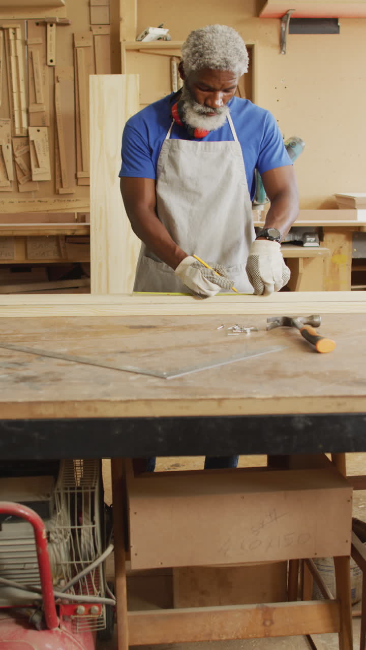 video vertical de un carpintero afroamericano de edad avanzada trabajando en un taller