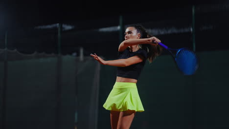 woman playing tennis at night