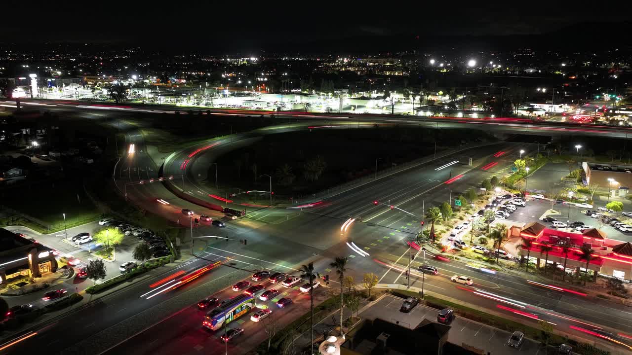 tiempo nocturno del lapso de tiempo de la rampa de entrada y salida en la carretera de california 10 autopista de redlands que se fusiona con el sur de tipecanoe ave en san bernardino tráfico ocupado larga exposición faros aéreos dolly de vuelta levantar
