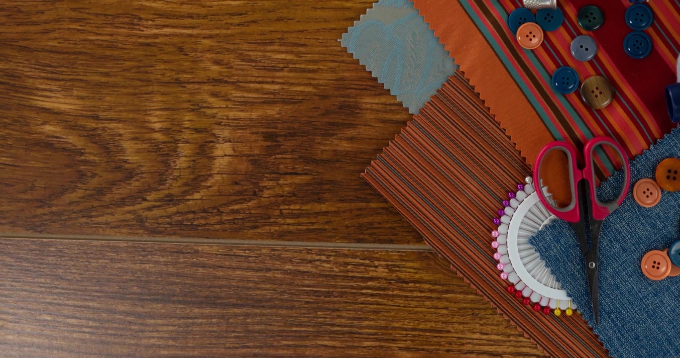 Animation of buttons, fabric, scissors and pins on wooden table top