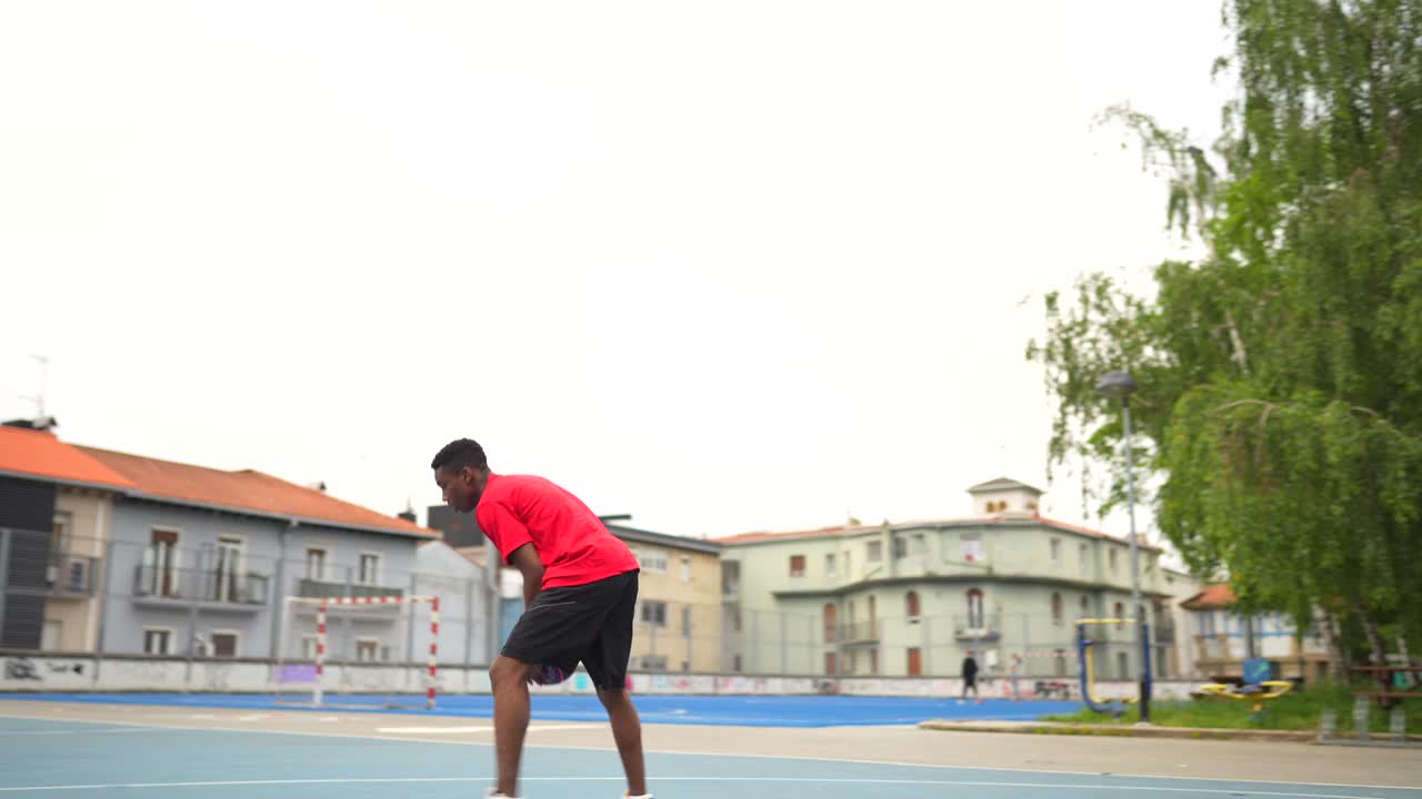 joven jugando al baloncesto en una cancha al aire libre