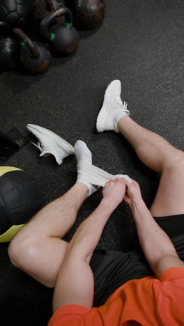 person applying ankle brace in gym