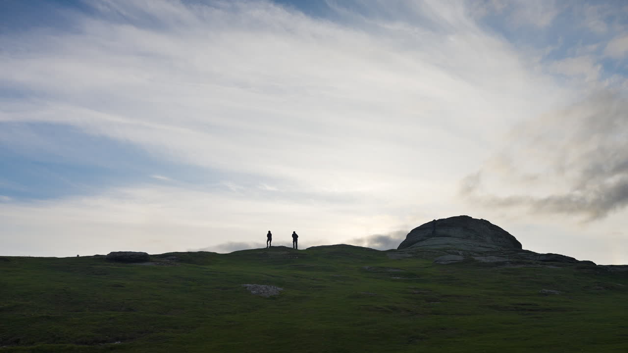 Hikers on a Mountaintop at Sunset