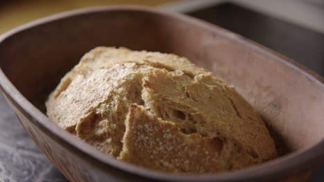 BAKING---Uncovering-sourdough-bread-fresh-from-the-oven,-slow-motion-close-up