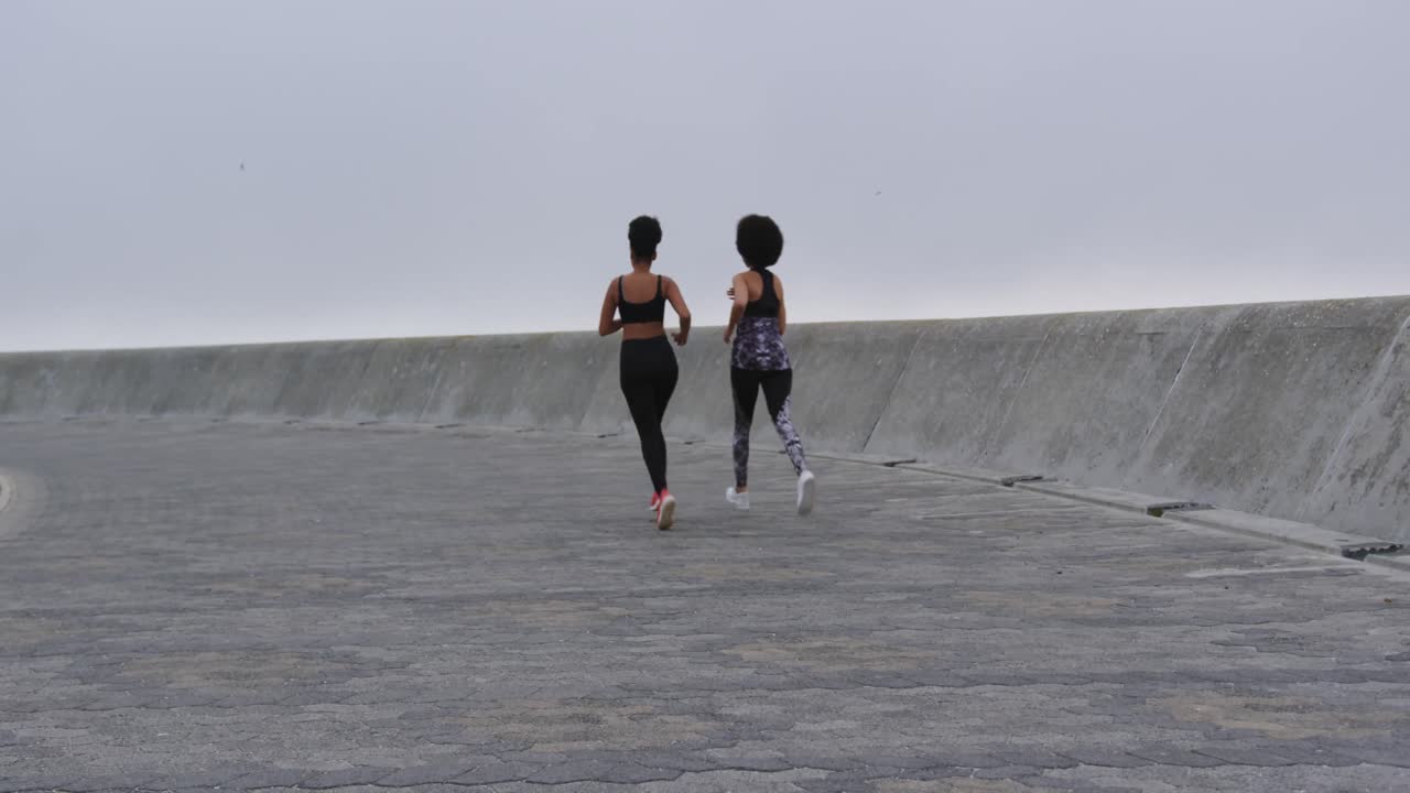 도크에서 달리는 두 명의 혼성 인종 여성