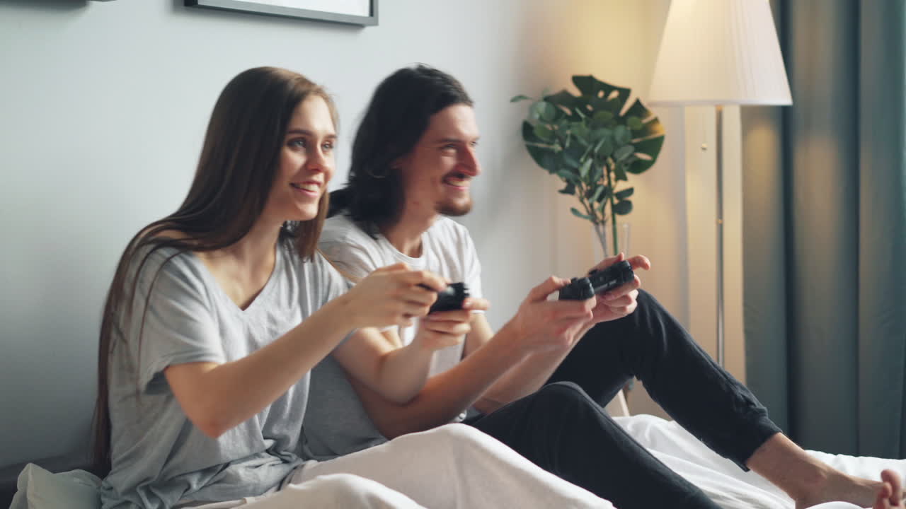 Coppia che gioca ai videogiochi a letto