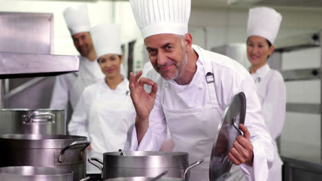 head chef smelling pot of soup making ok sign