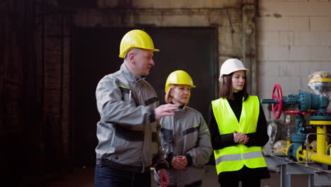 Three-workmates-walking-through-the-factory